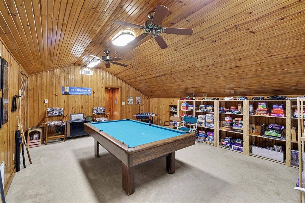 26 Brookhaven Drive, Lucas, TX 75002 Wood-paneled walls and ceiling, two ceiling fans with integrated lighting, built-in shelving, and light-toned carpeting