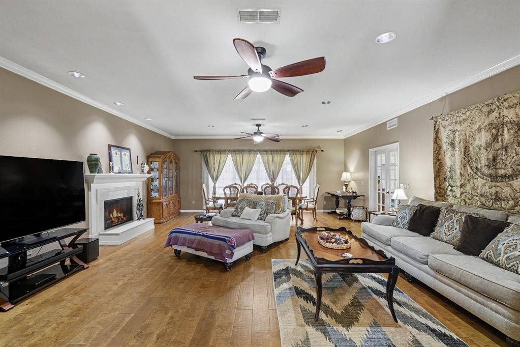 26 Brookhaven Drive, Lucas, TX 75002 Spacious living area featuring wood-finish flooring, a white mantel fireplace, and recessed lighting