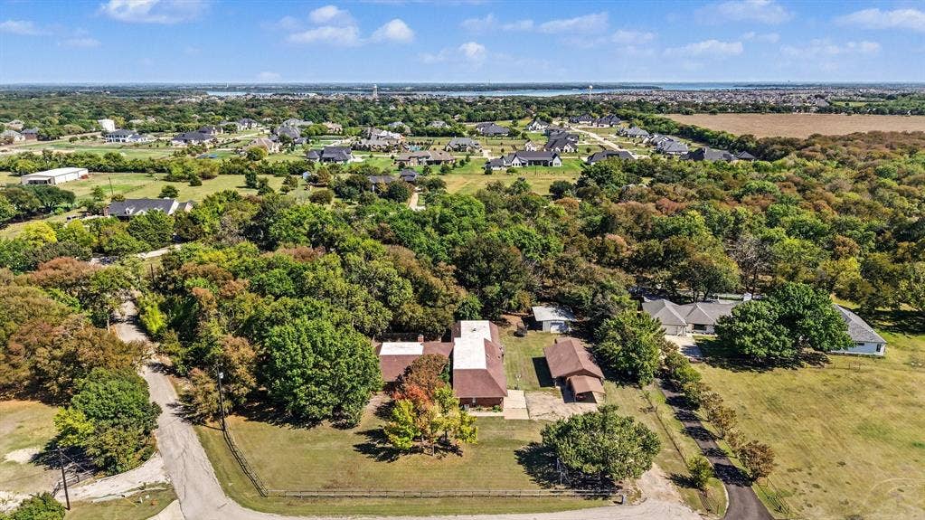 26 Brookhaven Drive, Lucas, TX 75002 Expansive property featuring a treed landscape, a paved driveway, and multiple structures