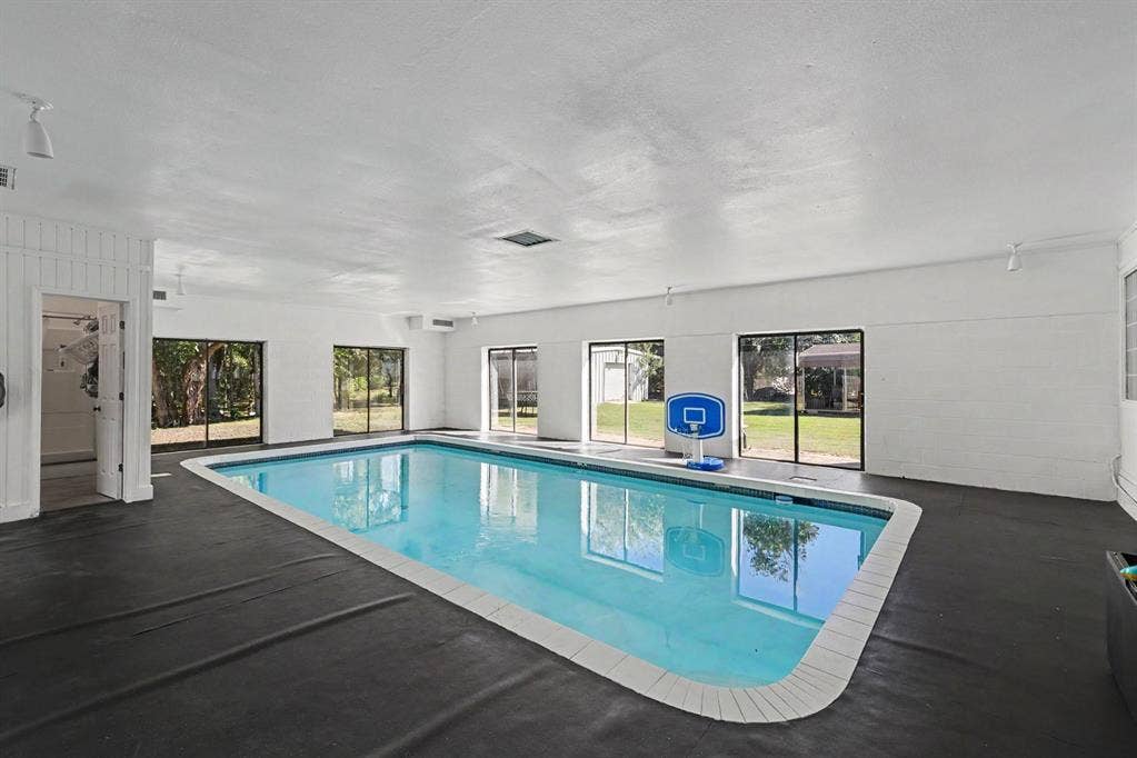 26 Brookhaven Drive, Lucas, TX 75002 Indoor swimming pool with direct outdoor access, perimeter deck, and multiple windows