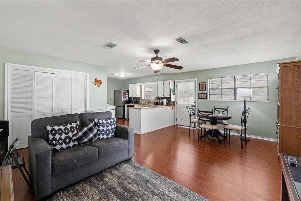26 Brookhaven Drive, Lucas, TX 75002 Hardwood-finish flooring, white louvered bifold doors, ceiling fan, white cabinetry, and a kitchen island