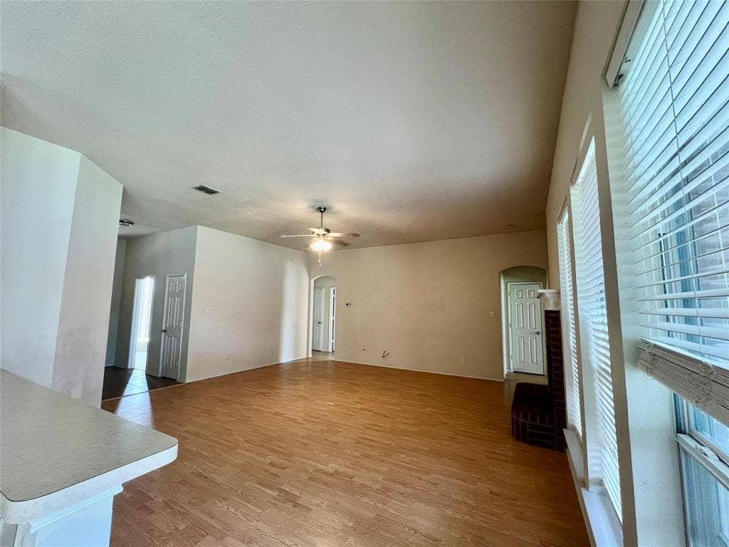 1801 Kathryn Court, Arlington, TX 76018 Wood-finish flooring throughout, ceiling fan with integrated lighting, window blinds, and arched doorways