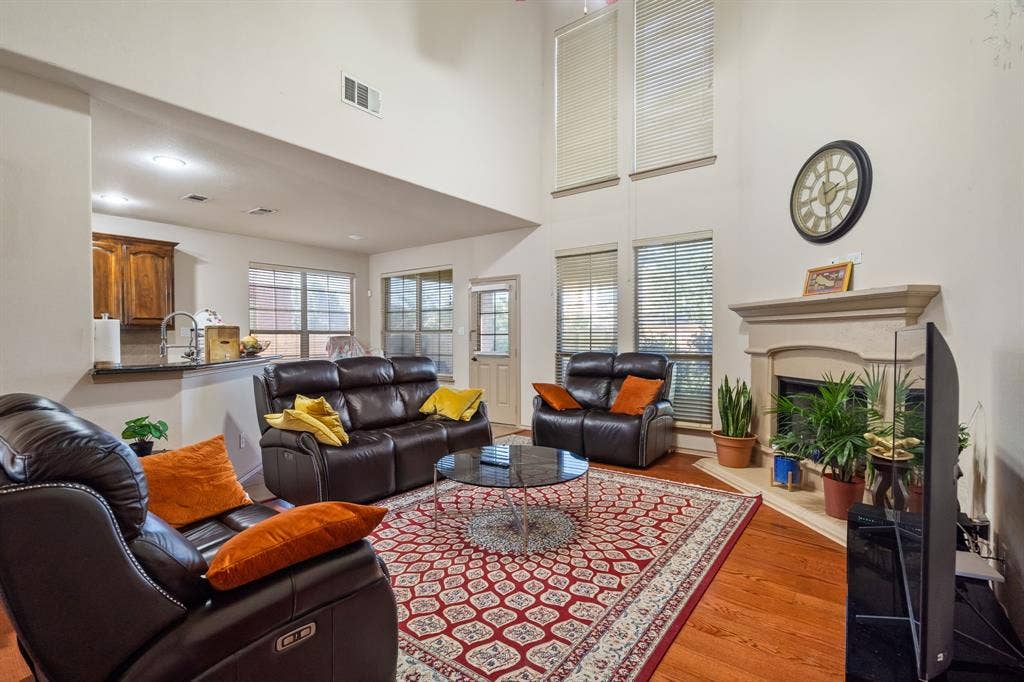 1620 Secretariat Lane, Irving, TX 75060 Living Room with 2-story ceiling, ceiling fan, lots of natural light, gas starter fireplace