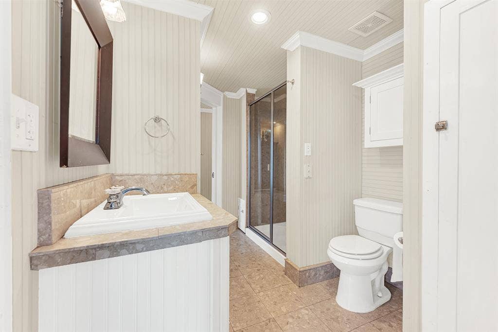 1425-1 Lone Star Road, Celina, TX 75009 Natural stone countertops and a spacious layout create a bathroom that's both timeless and designed for everyday convenience. The Jack-and-Jill arrangement gives adjoining bedrooms easy access while providing comfort and privacy for family or overnight guests.