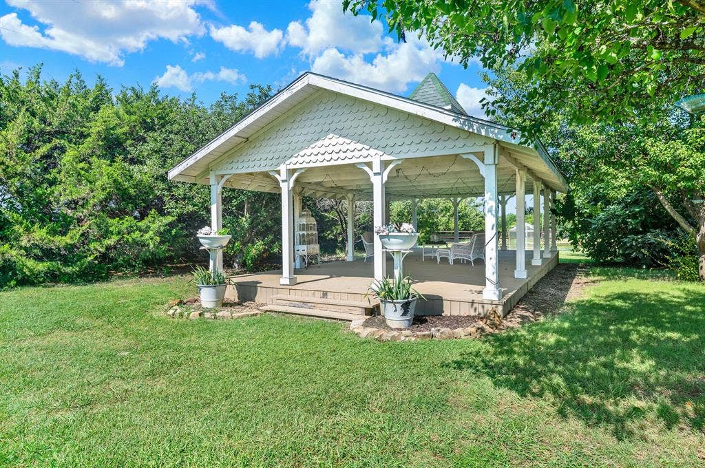 1425-1 Lone Star Road, Celina, TX 75009 The expansive covered pavilion is an inviting gathering space designed for entertaining, celebrations, or simply enjoying the peaceful country setting. With its open-air design, exposed timber framing, and generous footprint, it comfortably accommodates everything from family barbecues to special events while overlooking the beautifully maintained grounds.
