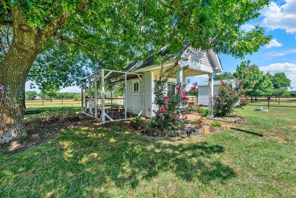 1425-1 Lone Star Road, Celina, TX 75009 Tucked beneath mature shade trees, the charming chicken coop adds to the property's authentic country lifestyle. Surrounded by established landscaping and open pasture views, this area offers space for hobby farming, fresh eggs, or gardening, blending practicality with the peaceful rural character that defines the property.