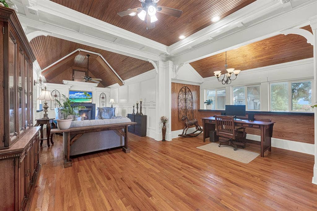 1425-1 Lone Star Road, Celina, TX 75009 This expansive family room blends warmth and functionality with rich wood ceilings, original hardwood floors, elegant millwork, and a cozy fireplace. A dedicated office nook with built-in workspace overlooks the grounds, while abundant natural light and an open layout create an inviting space for everyday living, working from home, or entertaining.