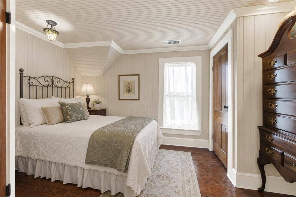 1425-1 Lone Star Road, Celina, TX 75009 Original hardwood floors and soft natural light create a bright, welcoming retreat, while the angled ceiling adds architectural character without sacrificing usable space. It's an inviting room for guests or family to unwind, offering a peaceful place to relax after a day spent enjoying the property.