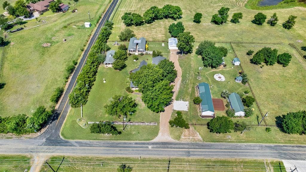 1425-1 Lone Star Road, Celina, TX 75009 Perfectly positioned on a spacious corner lot, this unique estate enjoys an impressive presence with mature trees, white fencing, and beautifully maintained grounds. Surrounded by newer luxury homes on acreage, the property offers the charm of country living while blending seamlessly into one of the area's most desirable rural neighborhoods.