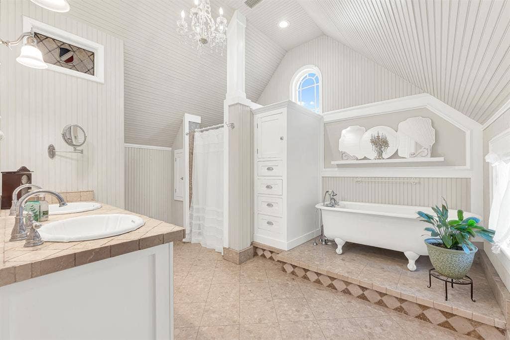 1425-1 Lone Star Road, Celina, TX 75009 A clawfoot soaking tub, soaring beadboard ceiling, and arched window fill the bath with timeless charm and soft natural light. Unwind with a long soak at the end of the day and enjoy a space designed for quiet moments of relaxation.