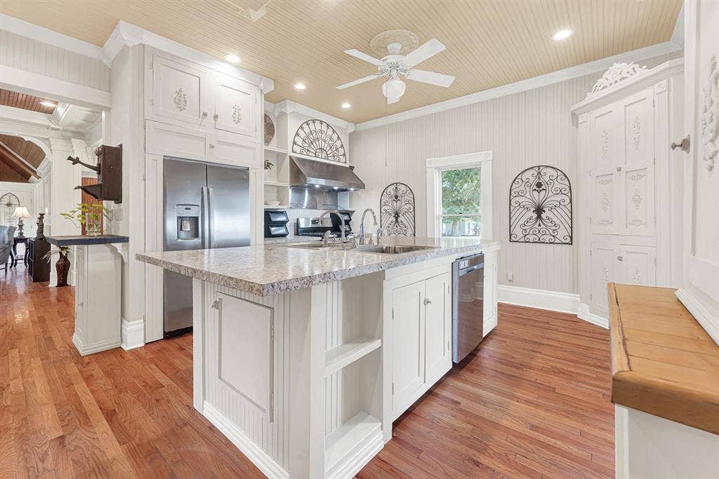 1425-1 Lone Star Road, Celina, TX 75009 The oversized island anchors the kitchen beneath soaring beadboard ceilings, creating an open workspace filled with natural light and timeless character. Picture everyone gathering here over pancakes and coffee before heading out to enjoy the property's wide-open spaces.