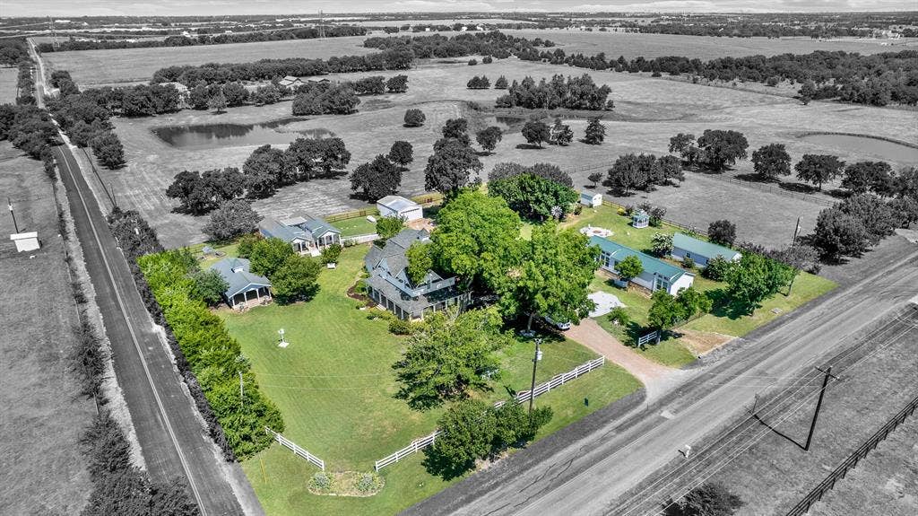 1425-1 Lone Star Road, Celina, TX 75009 This aerial view showcases the thoughtful layout of the 2.44-acre estate, where the historic main residence, four income-producing rental cottages, and numerous outdoor amenities come together in one beautifully maintained setting. Mature trees, expansive lawns, a covered pavilion, gazebo, fire pit, and open green space create a private country retreat with exceptional versatility and investment potential.