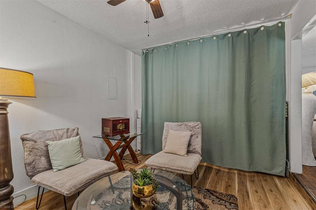 Interior space featuring wood-finish flooring and a ceiling-mounted fan with light fixture