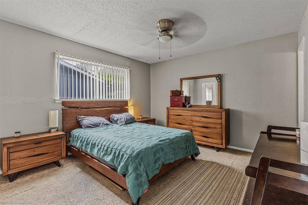 Room featuring neutral wall paint, carpeting, horizontal window blinds, and a ceiling fan with integrated lighting