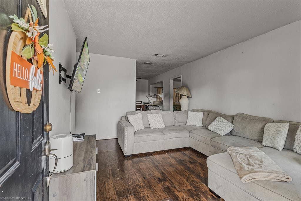 Interior space featuring wood-finish flooring and a wall-mounted television bracket