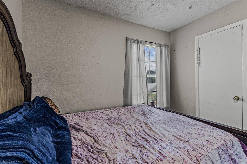 Single-pane window with horizontal blinds and a solid-core interior closet door featuring a polished brass knob