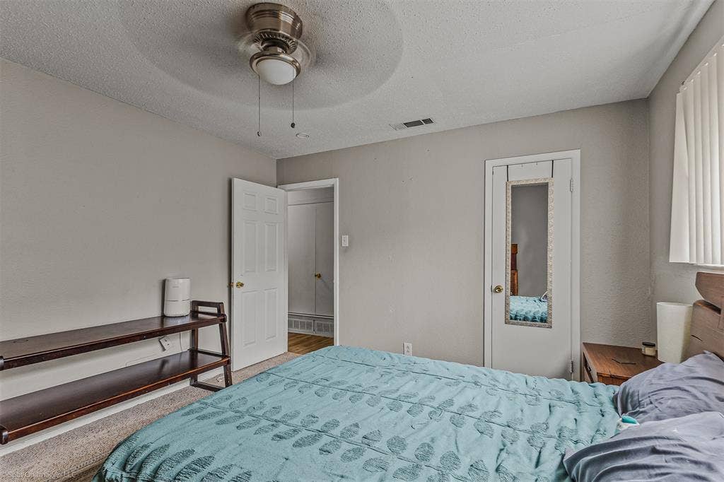 Room featuring neutral wall paint, a ceiling fan with integrated lighting, a solid-core interior door, and window blinds