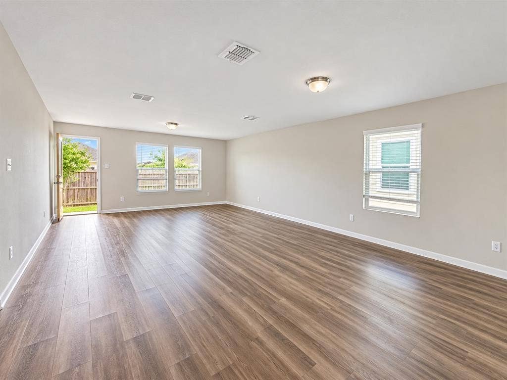 9226 Summerlee Street, Dallas, TX 75227 Wood-finish flooring, multiple windows with blinds, recessed lighting, and a rear exterior door