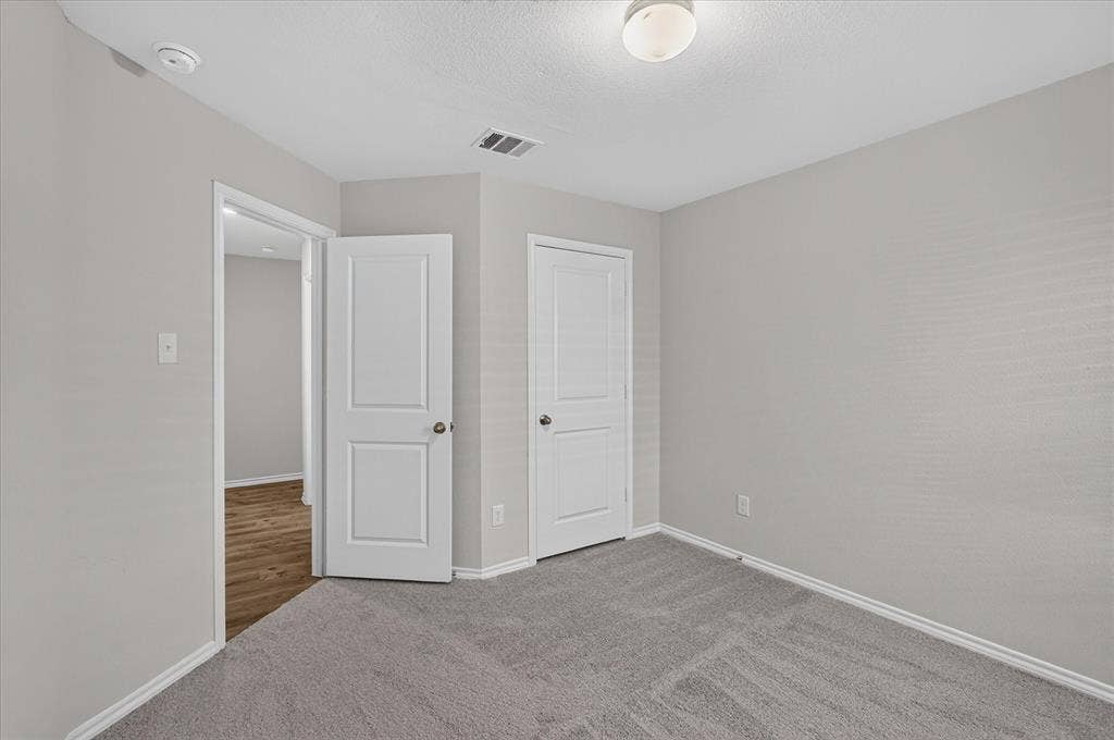 2428 Rosharon Drive, Forney, TX 75126 Light gray wall paint, textured ceiling, flush mount ceiling light fixture, white trim, and gray carpet flooring