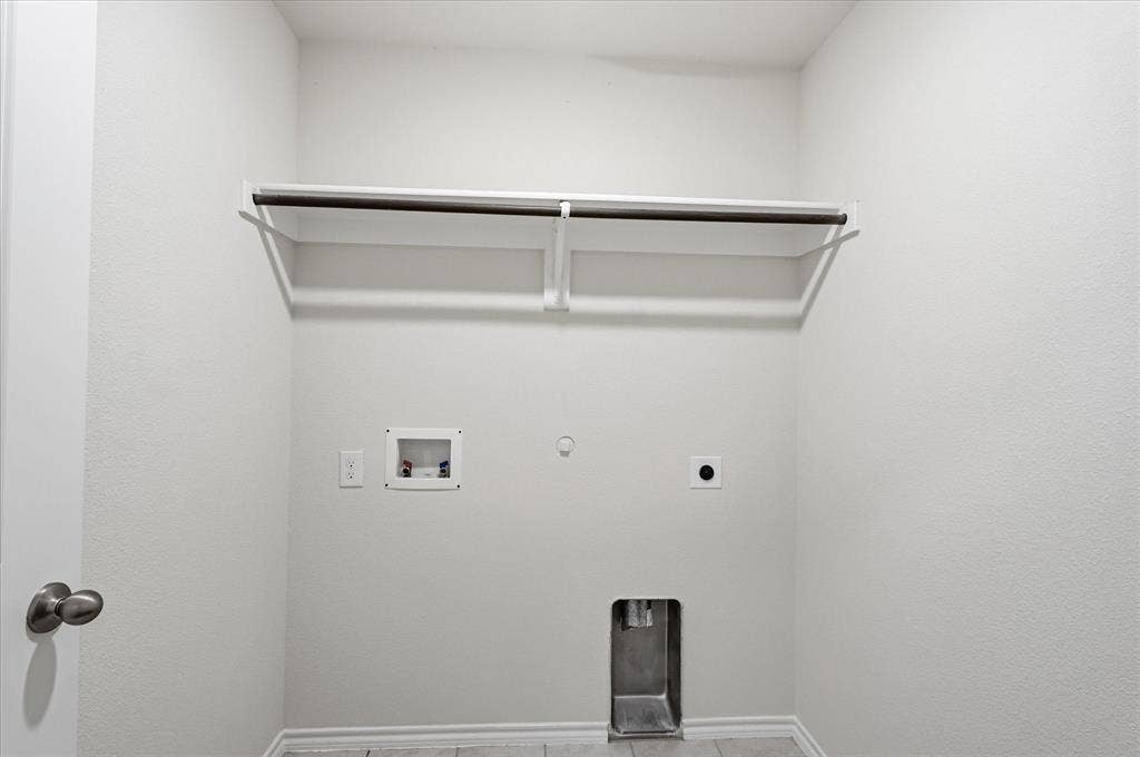 2428 Rosharon Drive, Forney, TX 75126 Utility room with a built-in shelving unit and clothing rod, featuring dedicated appliance hookups and neutral wall finishes