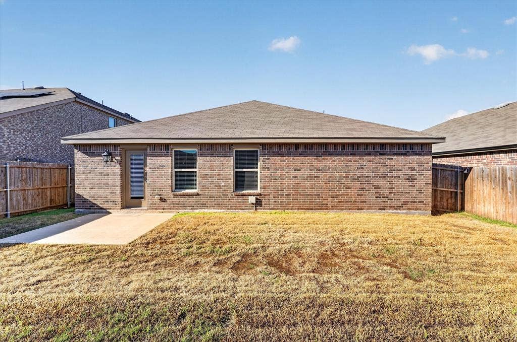 2428 Rosharon Drive, Forney, TX 75126 Brick single-story home featuring a hipped roof, multiple windows with dark frames, and a covered front entry
