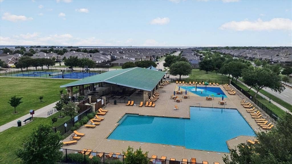 2428 Rosharon Drive, Forney, TX 75126 Swimming pool with integrated splash pad, covered pavilion, hardscaped pool deck, adjacent sports courts, and green space