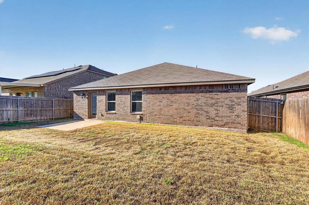 2428 Rosharon Drive, Forney, TX 75126 Brick exterior with multiple windows, leading to a concrete patio