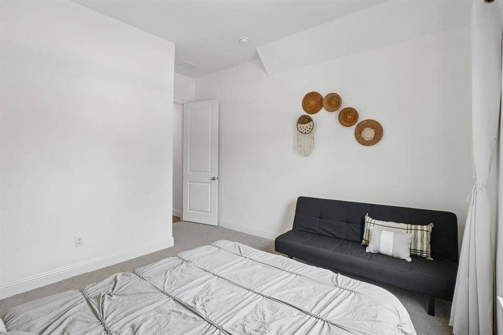 White walls, light-colored carpeting, and a white interior door