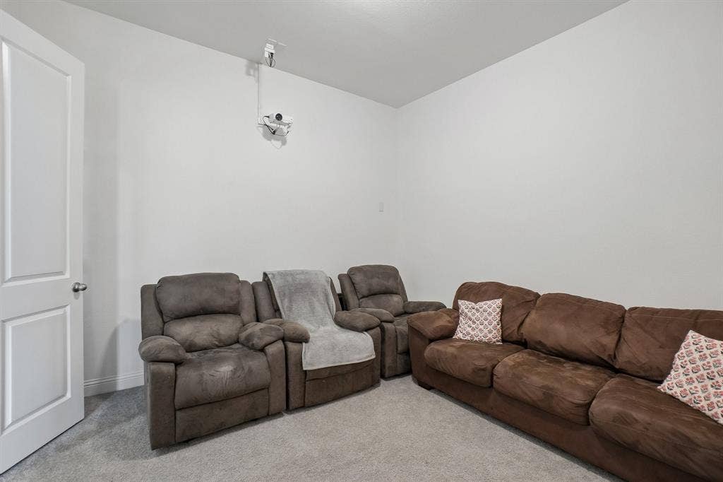 Recessed ceiling lighting, light gray wall paint, and gray carpet flooring