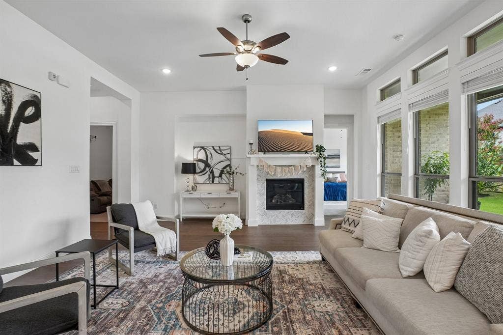 Living area with wood-finish flooring, a ceiling fan with integrated lighting, and recessed lighting