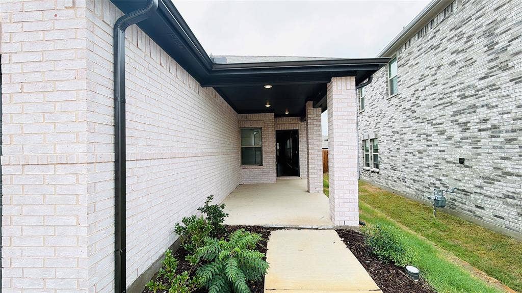 505 Blanton Street, McKinney, TX 75069 Covered entry with recessed lighting, brick columns, and a concrete walkway