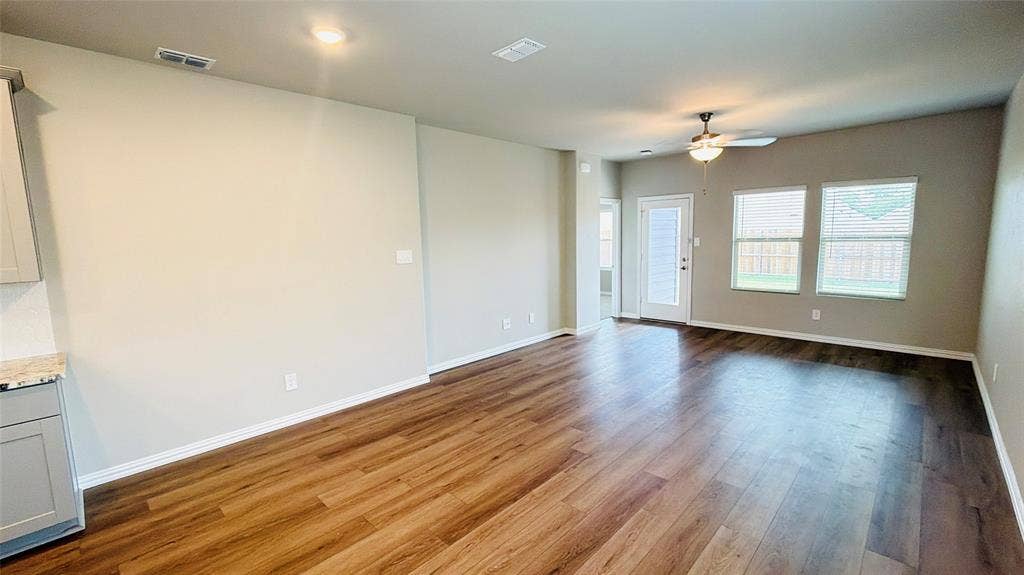 505 Blanton Street, McKinney, TX 75069 Expansive room featuring wood-finish flooring, multiple windows, a ceiling fan, and recessed lighting