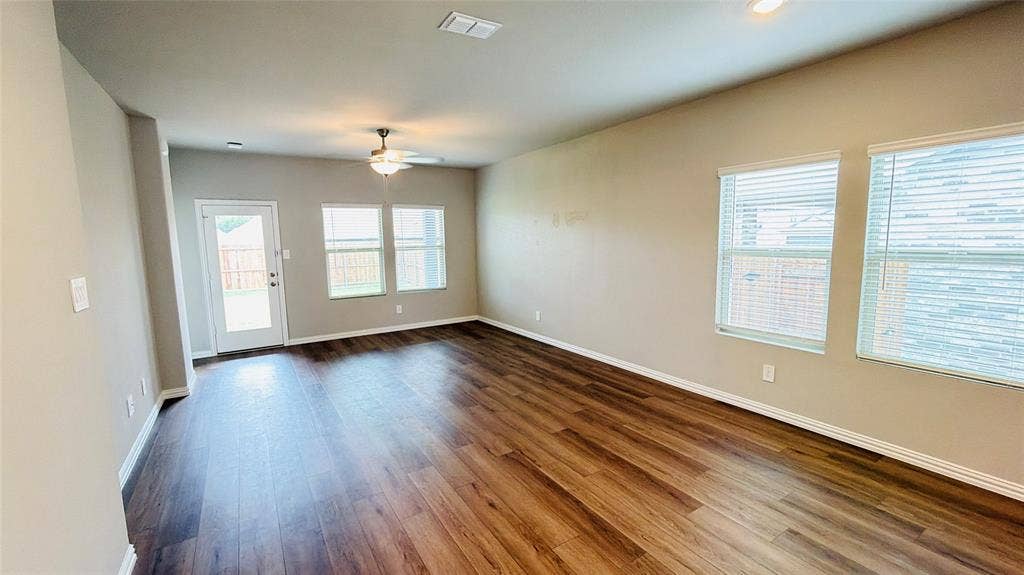 505 Blanton Street, McKinney, TX 75069 Wood-finish flooring, multiple windows with blinds, recessed lighting, ceiling fan, and a rear door providing exterior access