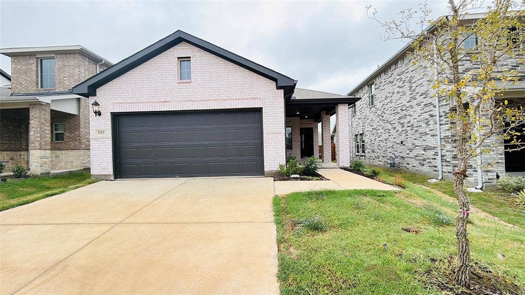 505 Blanton Street, McKinney, TX 75069 White brick exterior with dark trim and a dark garage door