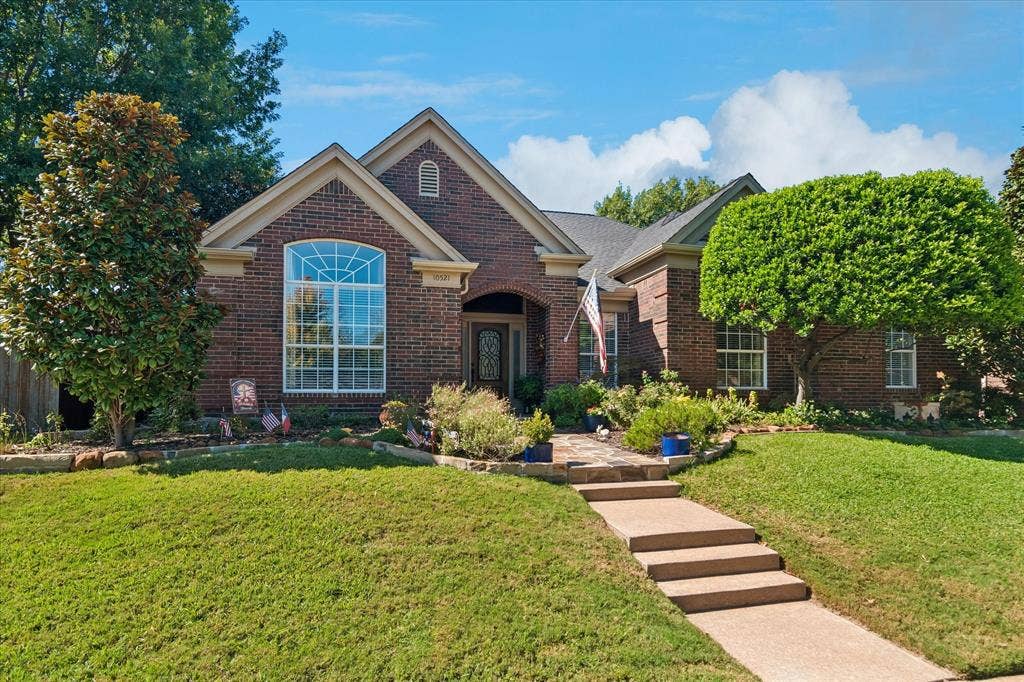 10521 Chablis Lane, Frisco, TX 75035 Brick exterior with gabled roof lines, featuring a large arched window and a covered entry