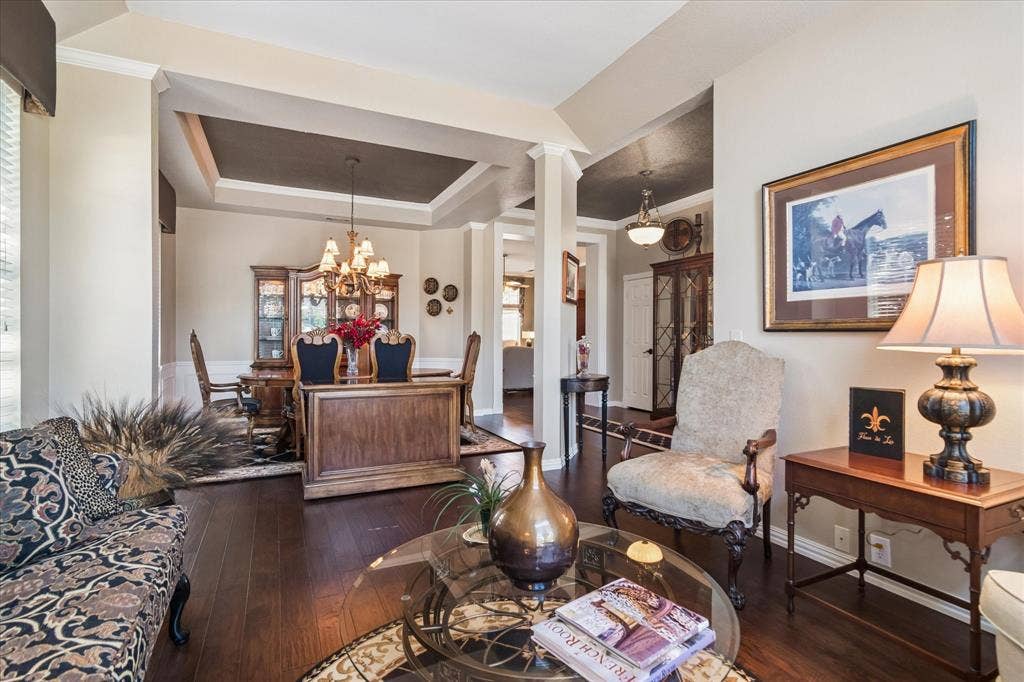 10521 Chablis Lane, Frisco, TX 75035 Hardwood-finish flooring, recessed tray ceiling, crown molding, and wainscoting details create a refined interior