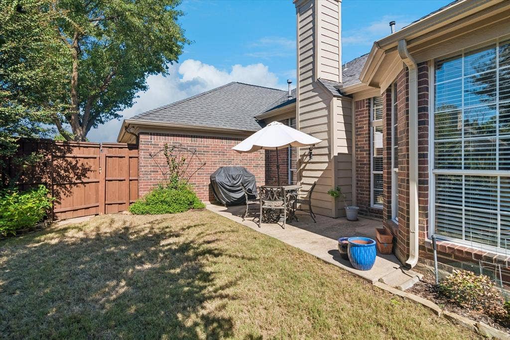 10521 Chablis Lane, Frisco, TX 75035 Private outdoor patio with a concrete slab, brick exterior, and wood fencing
