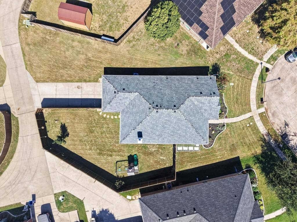 209 Northridge Drive, Wylie, TX 75098 Gable roofline with asphalt shingles, concrete driveway, and a fenced backyard with a storage shed