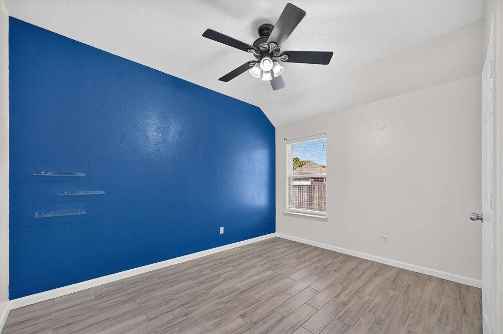 209 Northridge Drive, Wylie, TX 75098 Vaulted ceiling, wood-finish tile flooring, ceiling fan with integrated lighting, window with blinds, and clear wall-mounted shelving