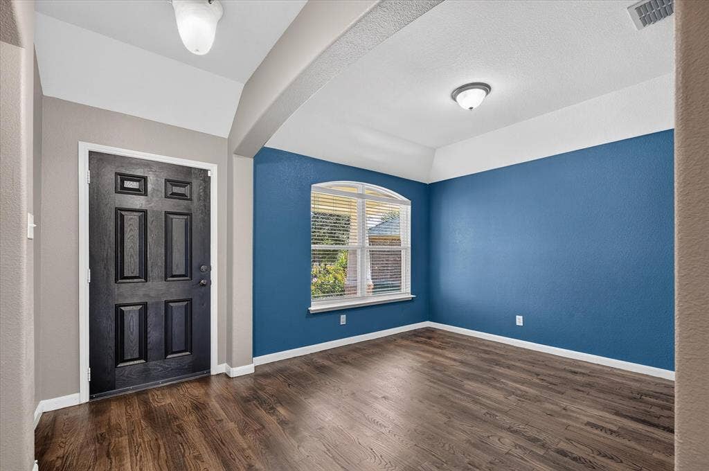 209 Northridge Drive, Wylie, TX 75098 Wood-finish flooring throughout, with a paneled entry door and an arched window