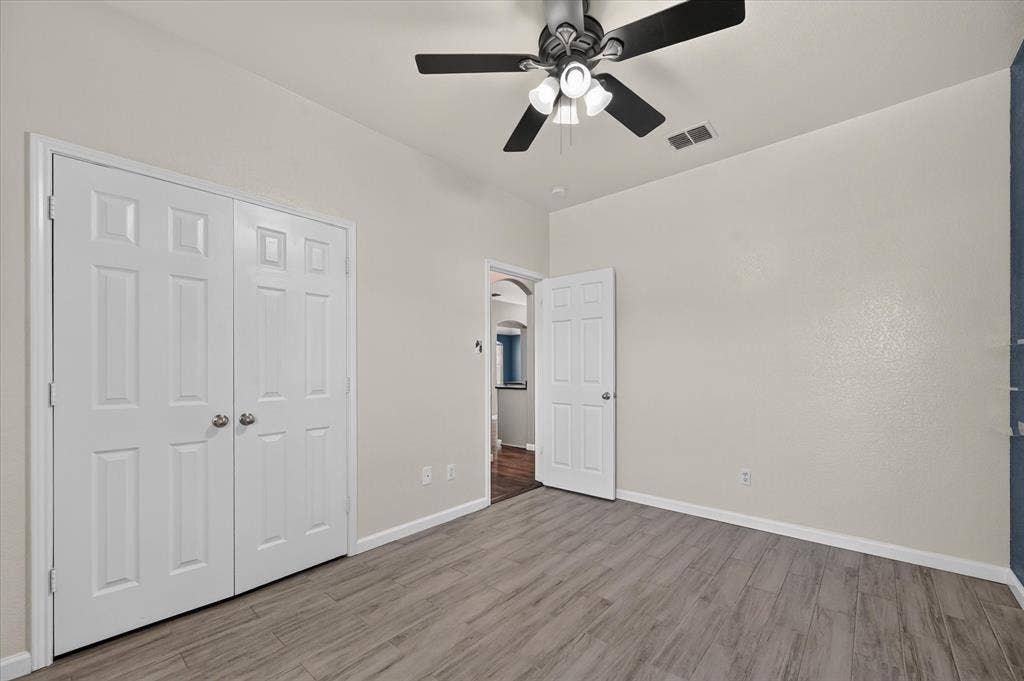 209 Northridge Drive, Wylie, TX 75098 Wood-finish flooring, ceiling fan with integrated lighting, paneled doors, and neutral wall tones