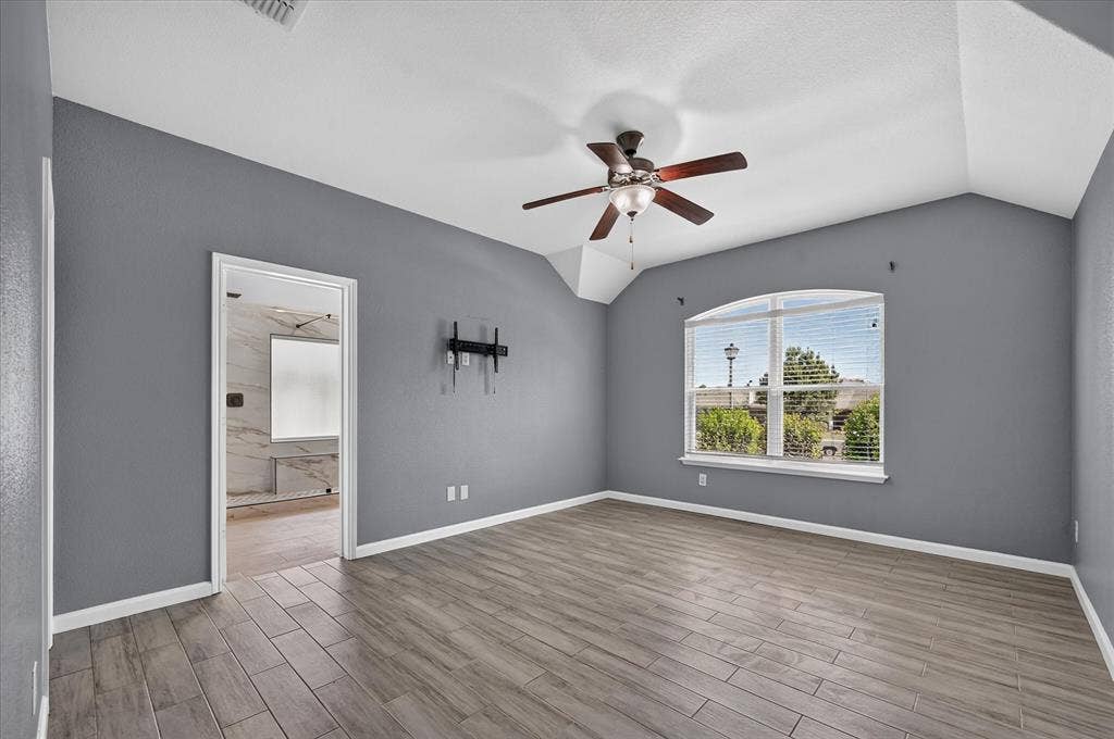 209 Northridge Drive, Wylie, TX 75098 Spacious bedroom with gray walls, wood-finish flooring, and abundant natural light from dual windows