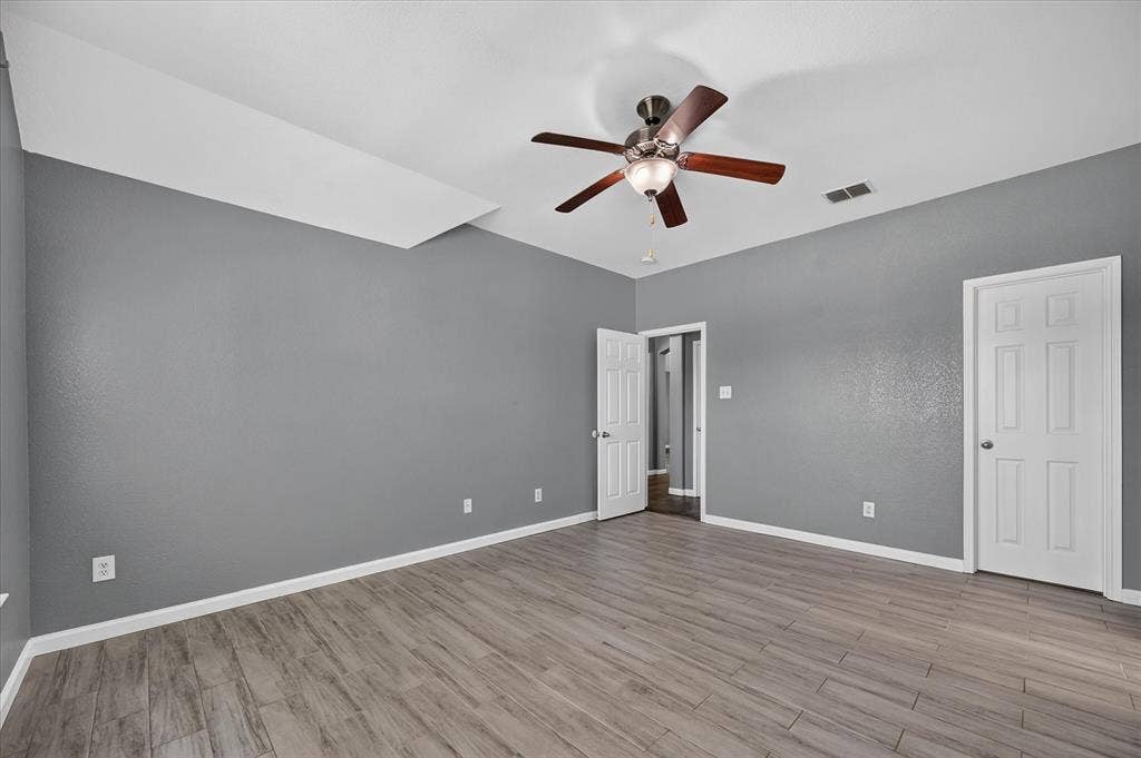 209 Northridge Drive, Wylie, TX 75098 Wood-finish plank flooring, gray painted walls, and a ceiling fan with light fixture