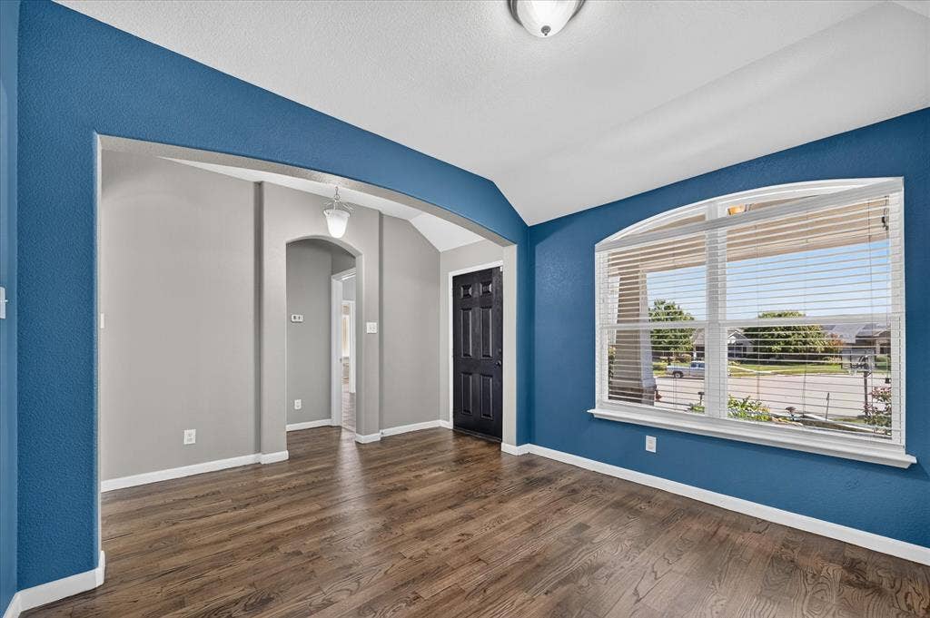209 Northridge Drive, Wylie, TX 75098 Wood-finish flooring, arched entryway, vaulted ceiling, recessed lighting, and a large arched window with blinds