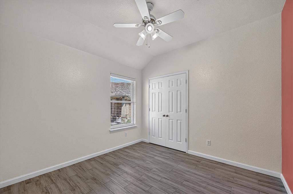 209 Northridge Drive, Wylie, TX 75098 Vaulted ceiling with a ceiling fan, window with blinds, wood-finish flooring, and panel doors