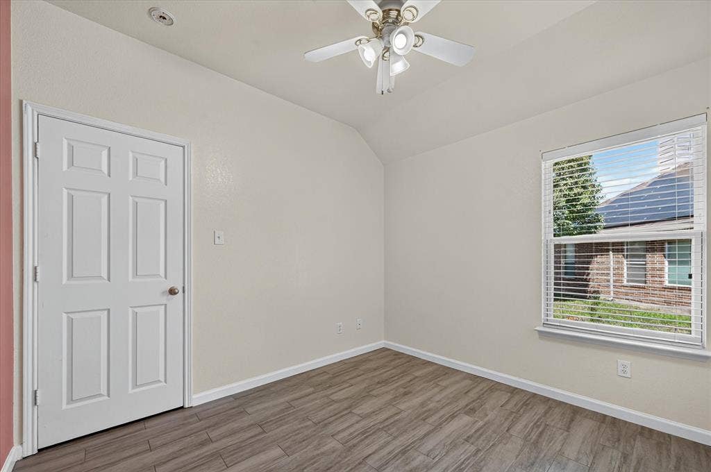 209 Northridge Drive, Wylie, TX 75098 Bright bedroom featuring wood-finish flooring, a ceiling fan with integrated lighting, large double-hung window with natural light, and a six-panel closet door