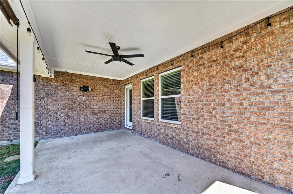 209 Northridge Drive, Wylie, TX 75098 Covered patio with a concrete surface, brick exterior, ceiling fan, and string lighting
