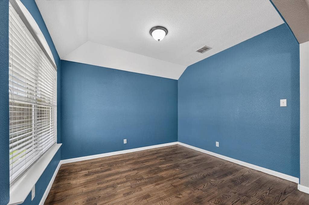209 Northridge Drive, Wylie, TX 75098 Vaulted ceiling, wood-finish flooring, and a window with horizontal blinds