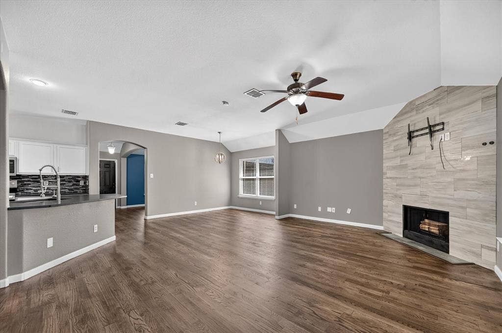 209 Northridge Drive, Wylie, TX 75098 Spacious living area featuring wood-finish flooring, a tiled fireplace, and a ceiling fan