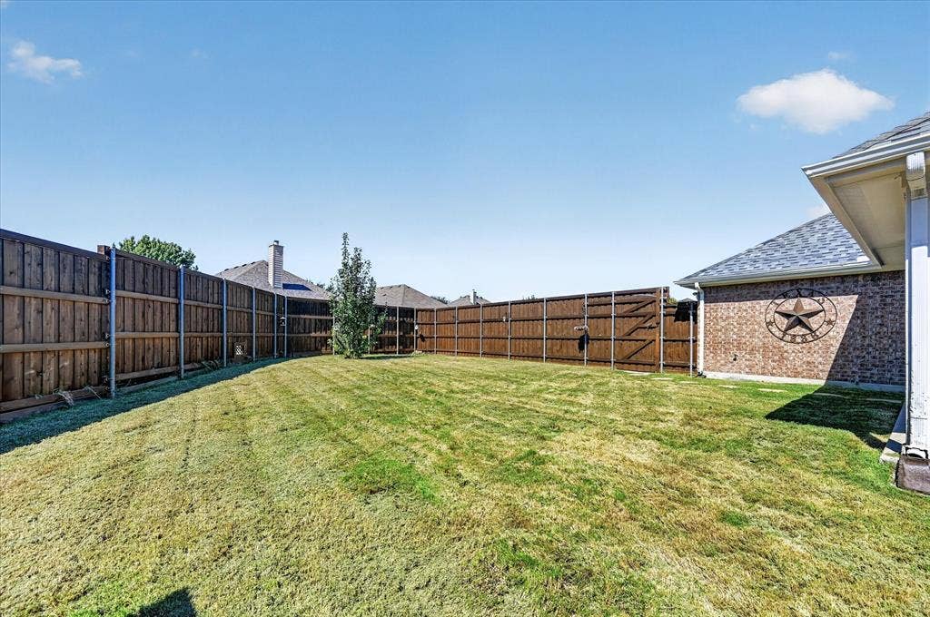 209 Northridge Drive, Wylie, TX 75098 Expansive backyard featuring a wood privacy fence and a small tree